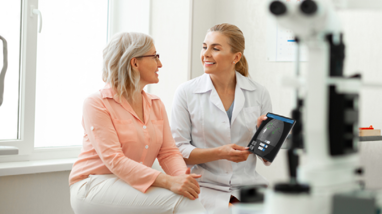 Doctor and patient looking at an optometry EHR diagnostic image on tablet